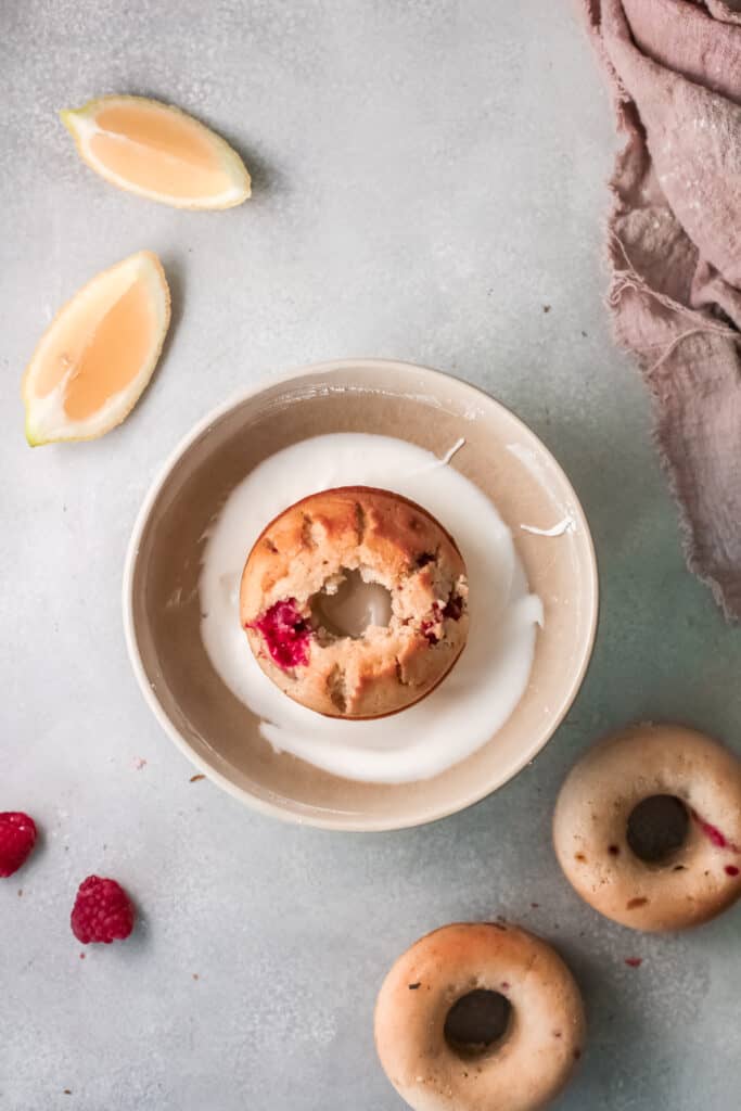 donuts with raspberries and milk in a bowl.